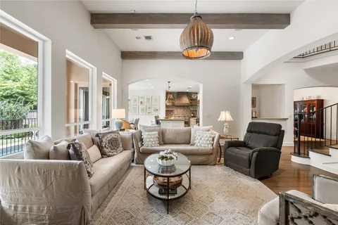 a living room with furniture a chandelier and a large window