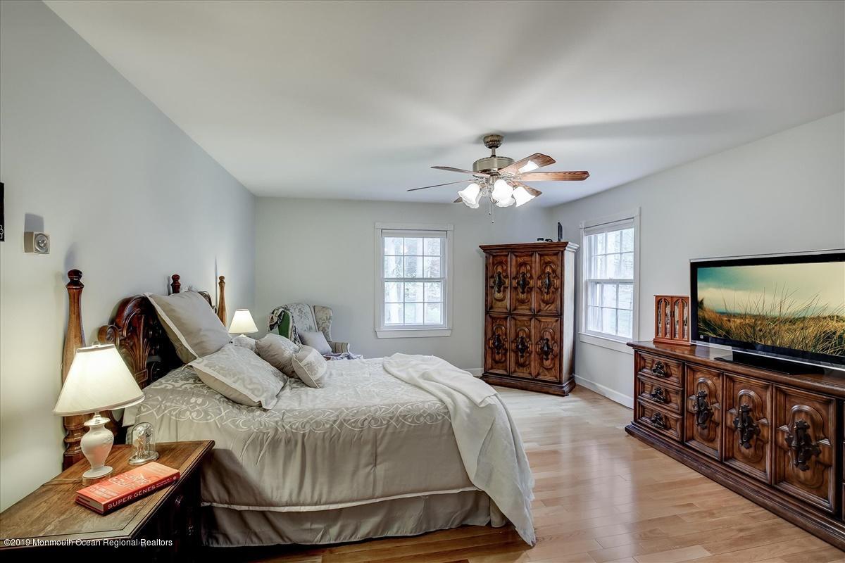 111 Reids Hill Road Morganville, NJ 07751 - Photo 15 of 39 a bedroom with a bed and a flat tv screen on dresser