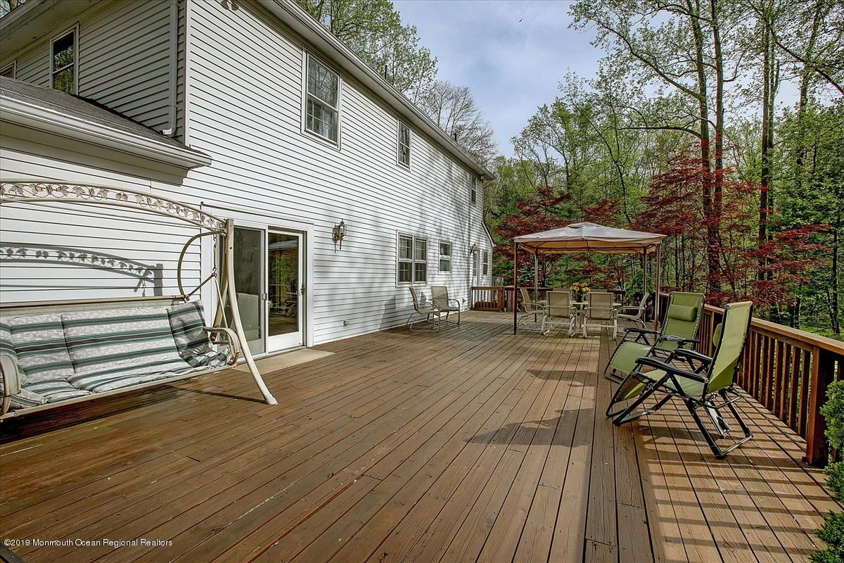 111 Reids Hill Road Morganville, NJ 07751 - Photo 27 of 39 a view of a patio with table and chairs with wooden floor and fence