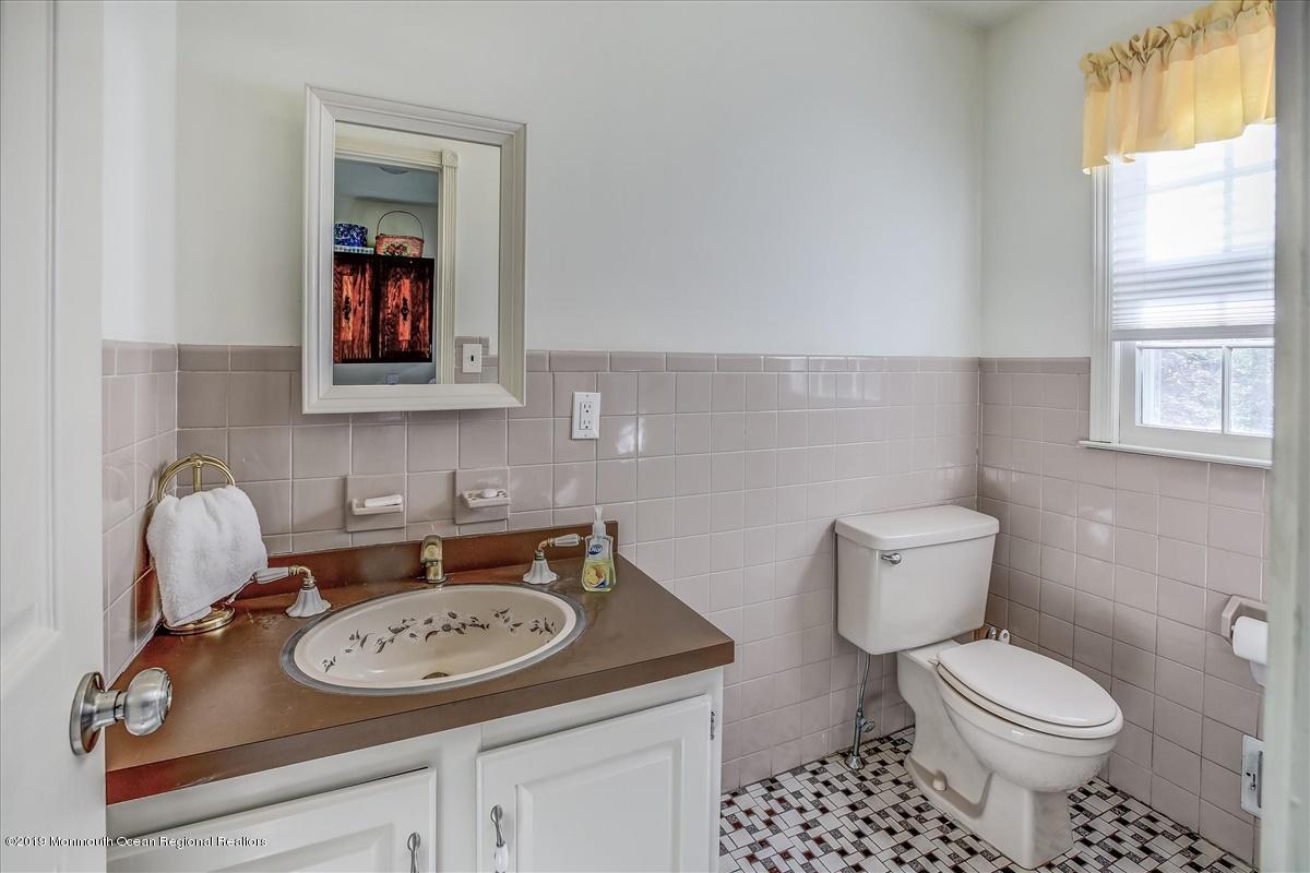 111 Reids Hill Road Morganville, NJ 07751 - Photo 10 of 39 a bathroom with a toilet a sink and a window