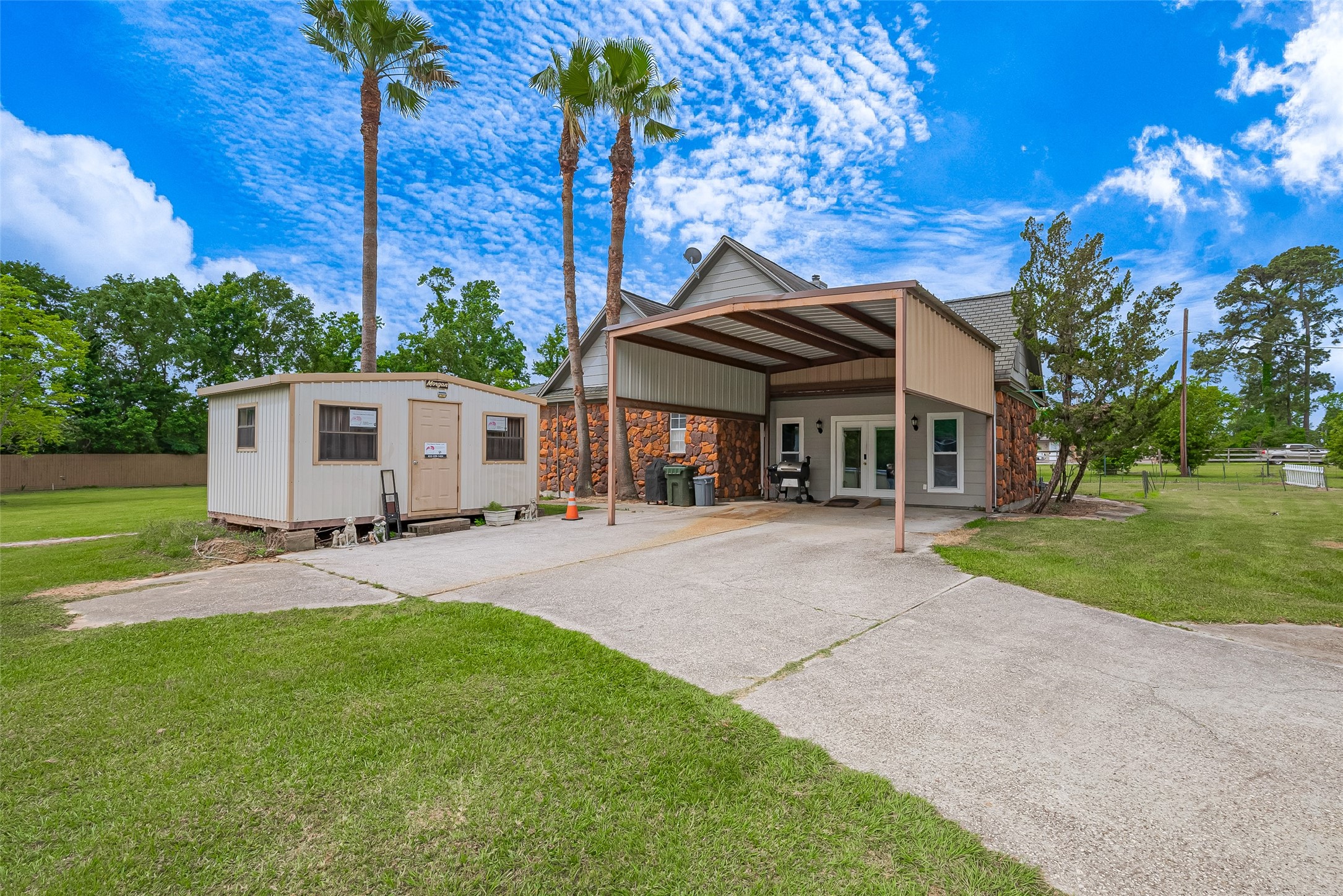 2499 Southline Road Conroe, TX 77384 - Photo 5 of 49 Covered carport and spacious driveway with additional storage building offering extra versatility and workspace.