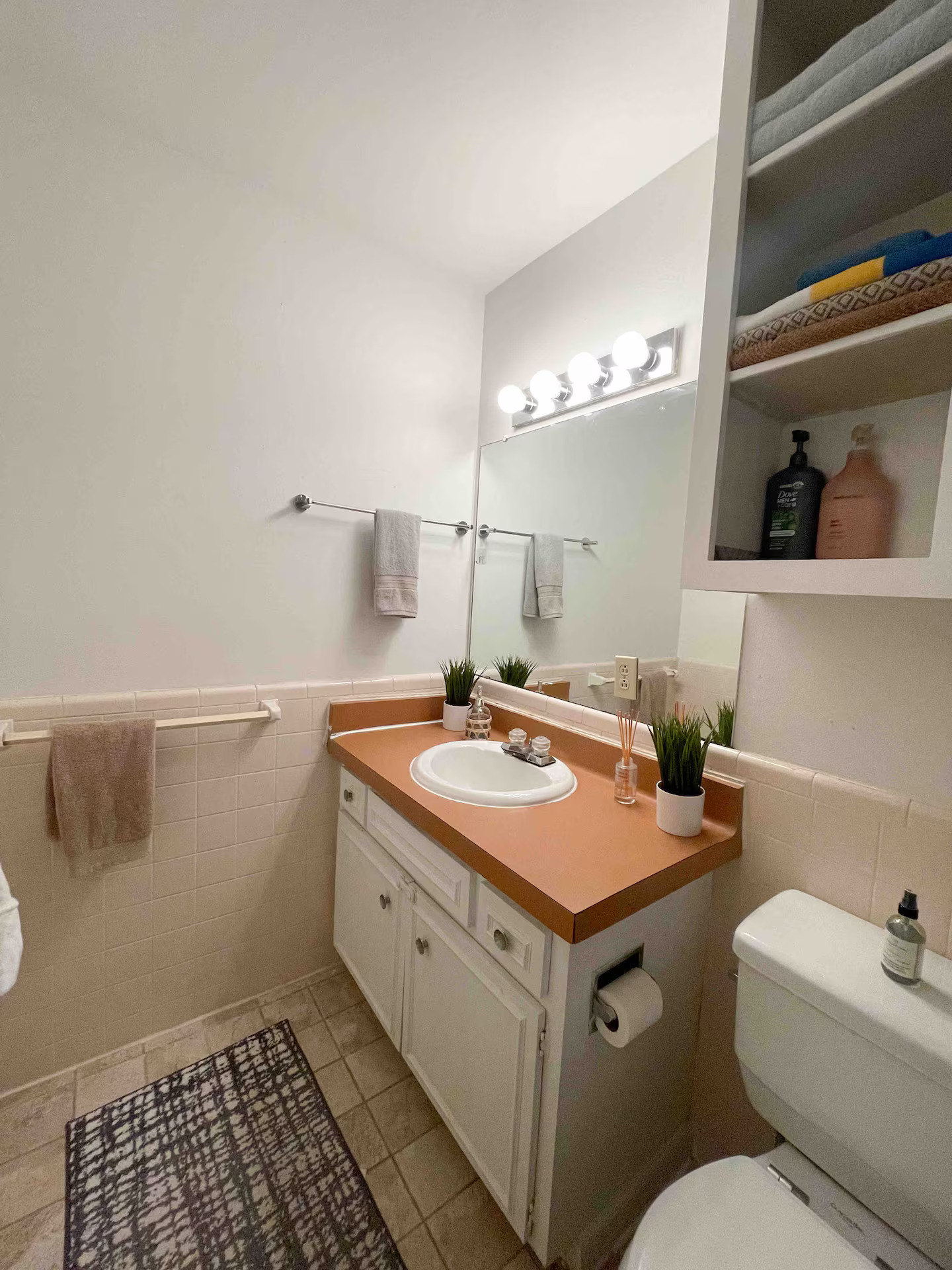 2404 Longview Street, Unit 204 Austin, TX 78705 - Photo 6 of 9 Half bath featuring tile walls, vanity, and a wainscoted wall