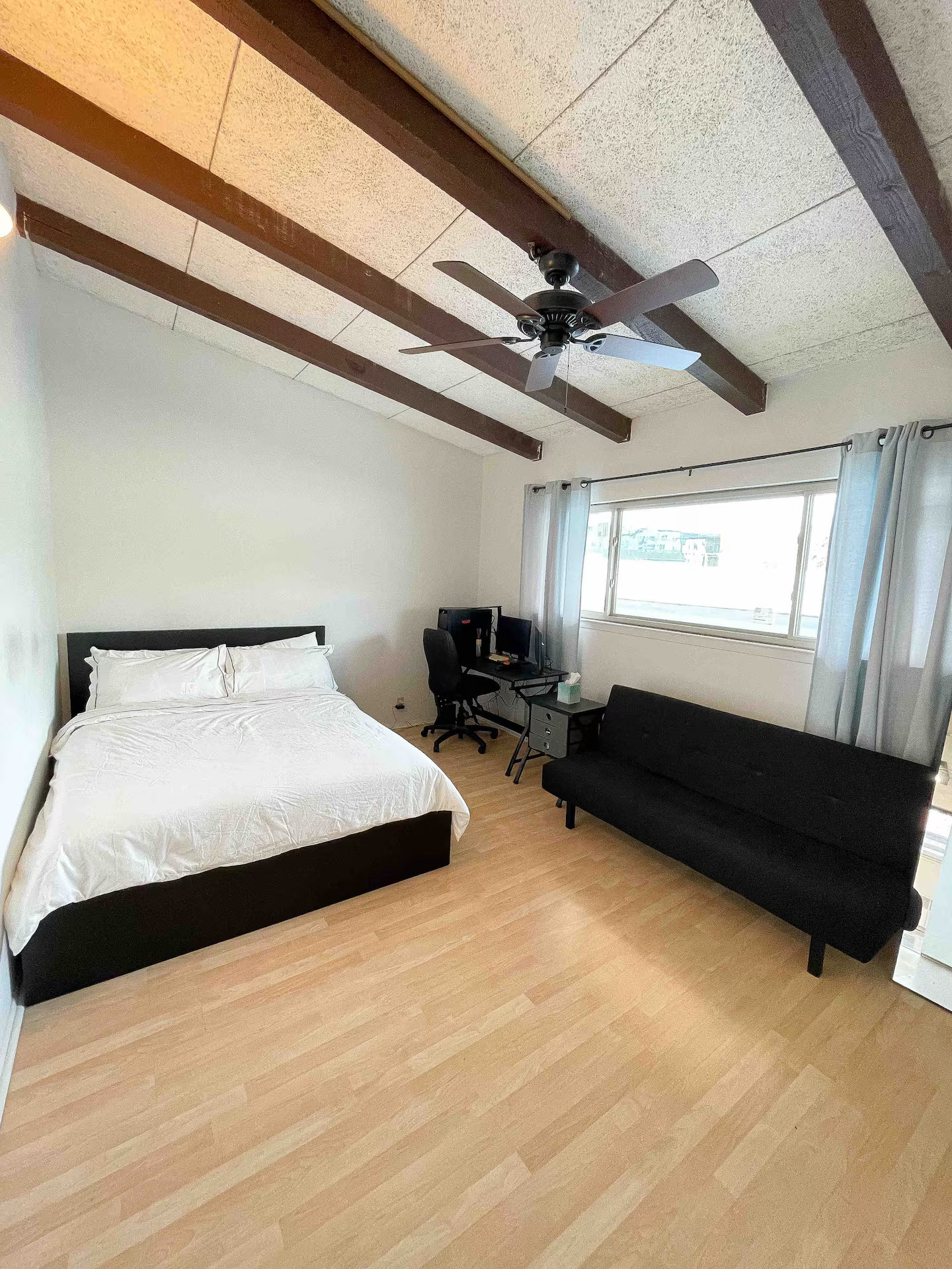 2404 Longview Street, Unit 204 Austin, TX 78705 - Photo 8 of 9 Bedroom featuring beamed ceiling, light wood-style flooring, and a ceiling fan