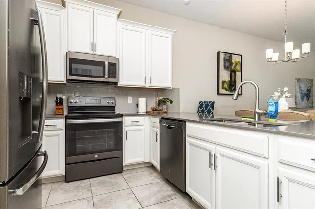 a kitchen with white cabinets and stainless steel appliances