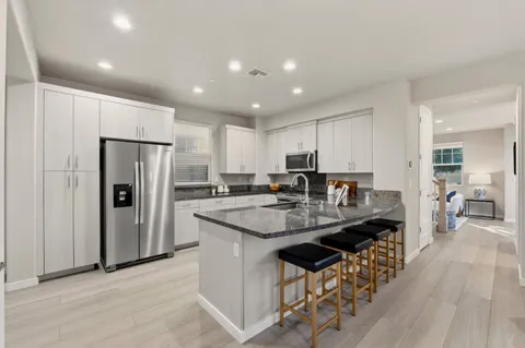 a kitchen with counter top space a sink refrigerator and cabinets