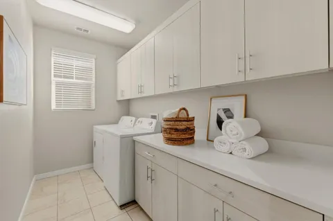 a utility room with cabinets washer and dryer
