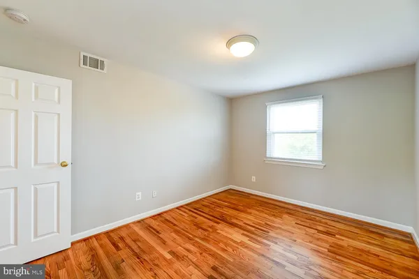 a view of a room with wooden floor and fan