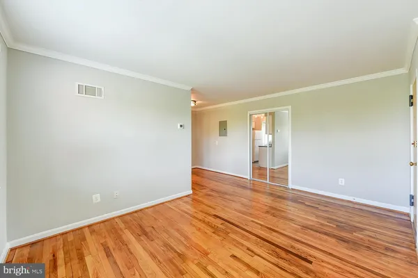 a view of an empty room with wooden floor