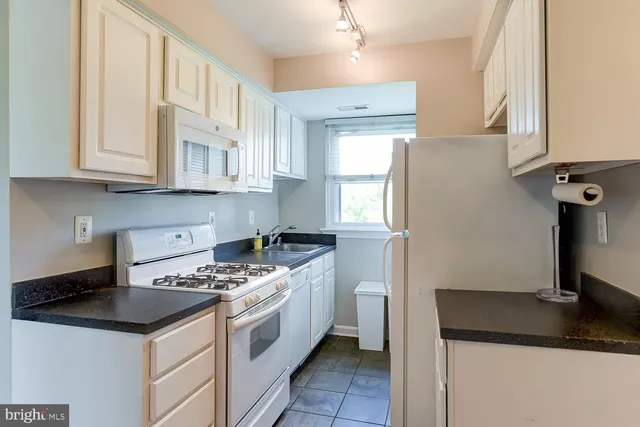 a kitchen with a sink a stove and a refrigerator