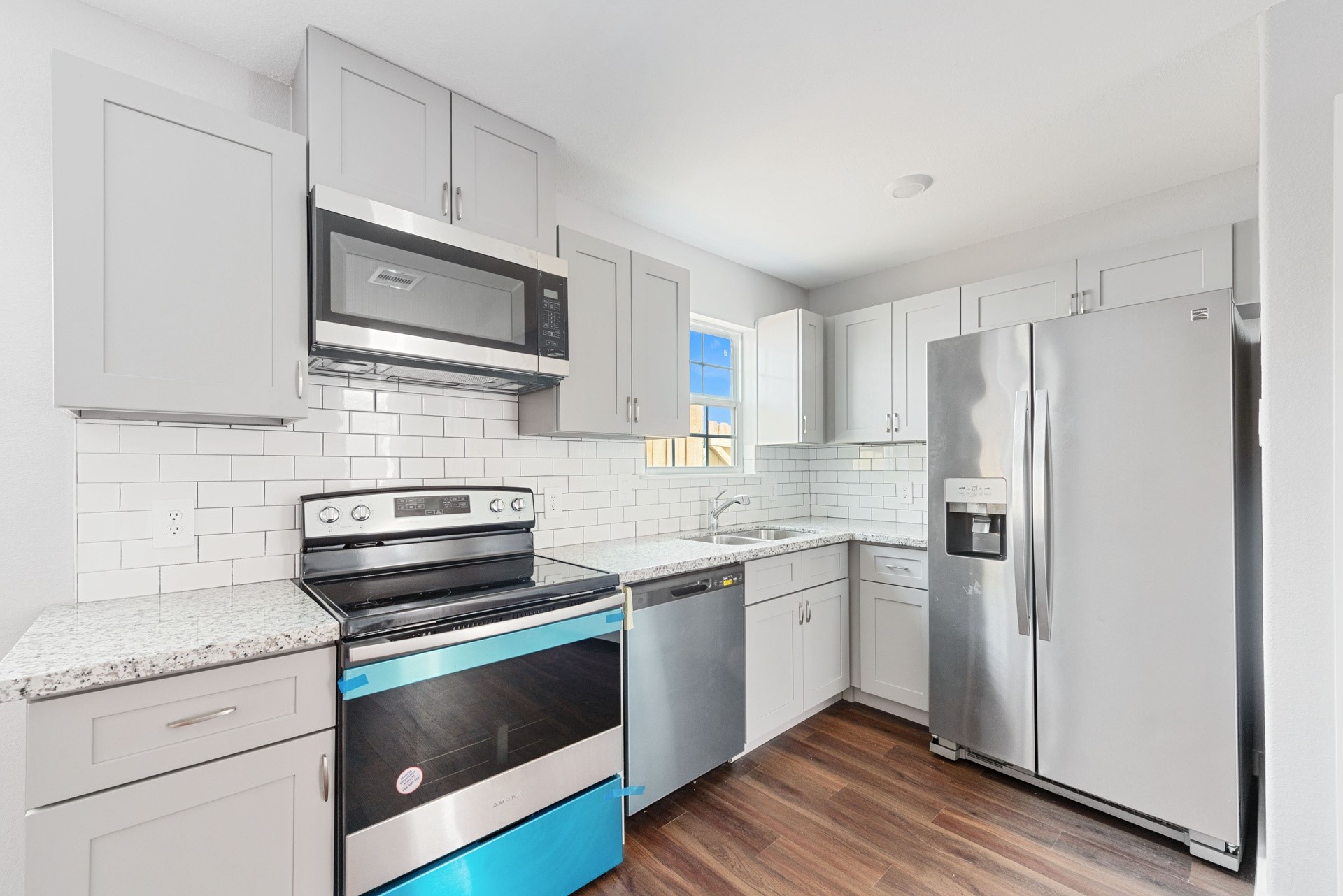 6809 Glass Street Houston, TX 77016 - Photo 18 of 29 a kitchen with cabinets stainless steel appliances a sink and wooden floor