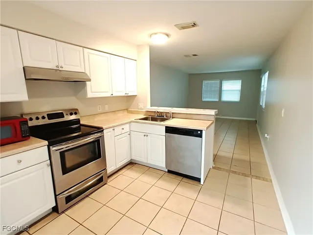 a kitchen with a stove sink and cabinets