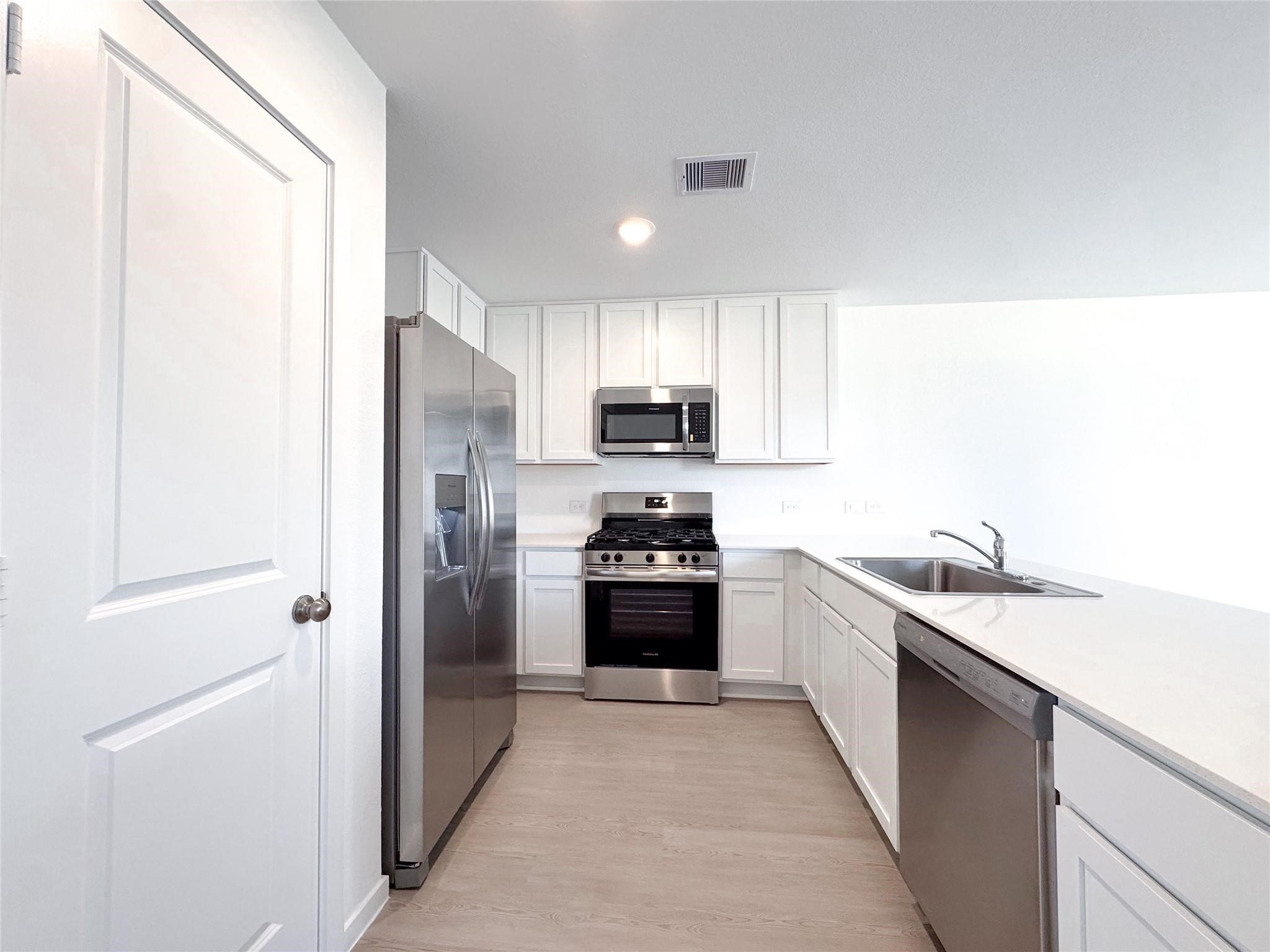 12431 Wild Strawberry Road Houston, TX 77038 - Photo 2 of 18 a kitchen with stainless steel appliances granite countertop a refrigerator and a sink