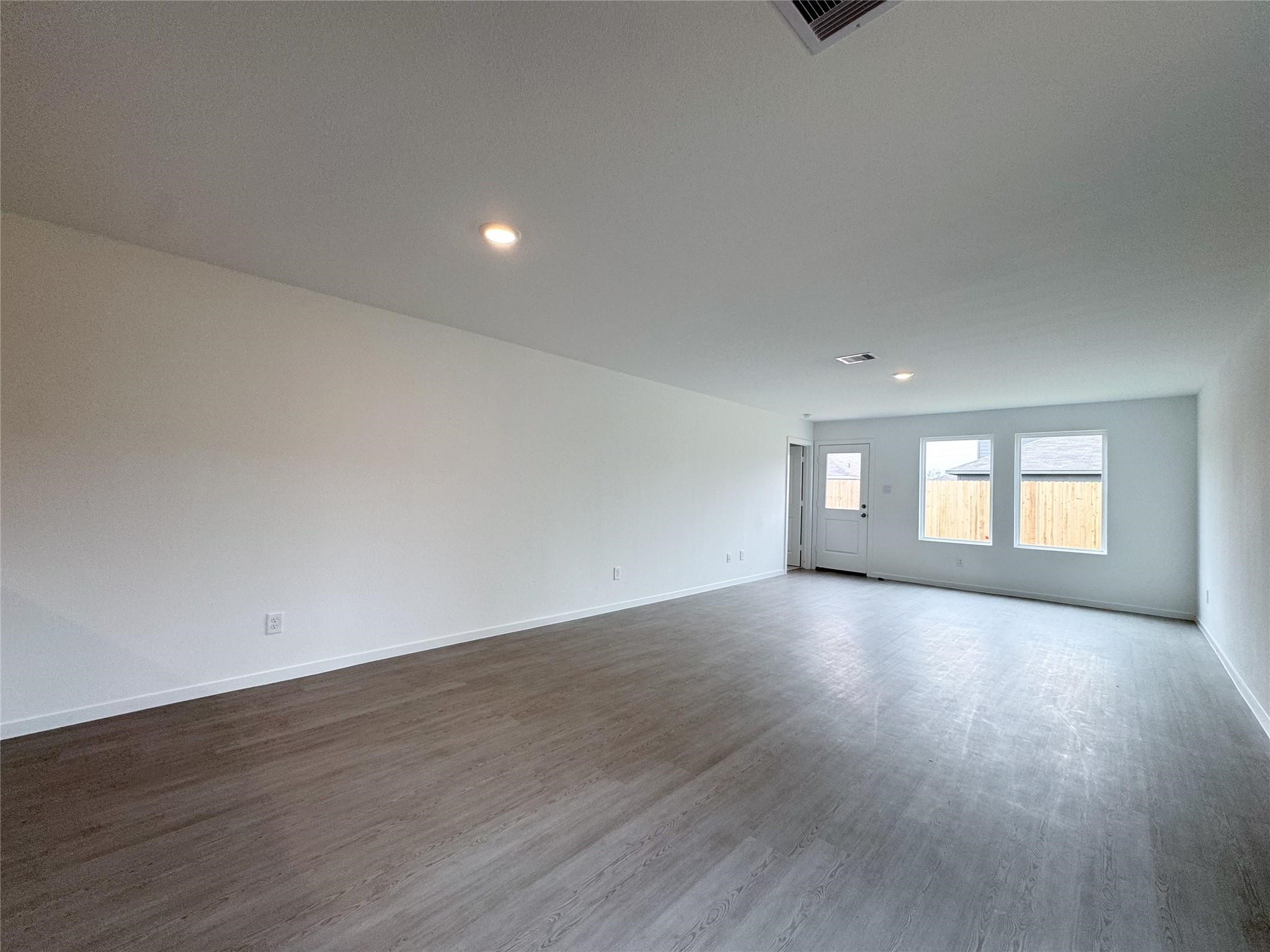 12431 Wild Strawberry Road Houston, TX 77038 - Photo 8 of 18 a view of empty room with wooden floor and fan