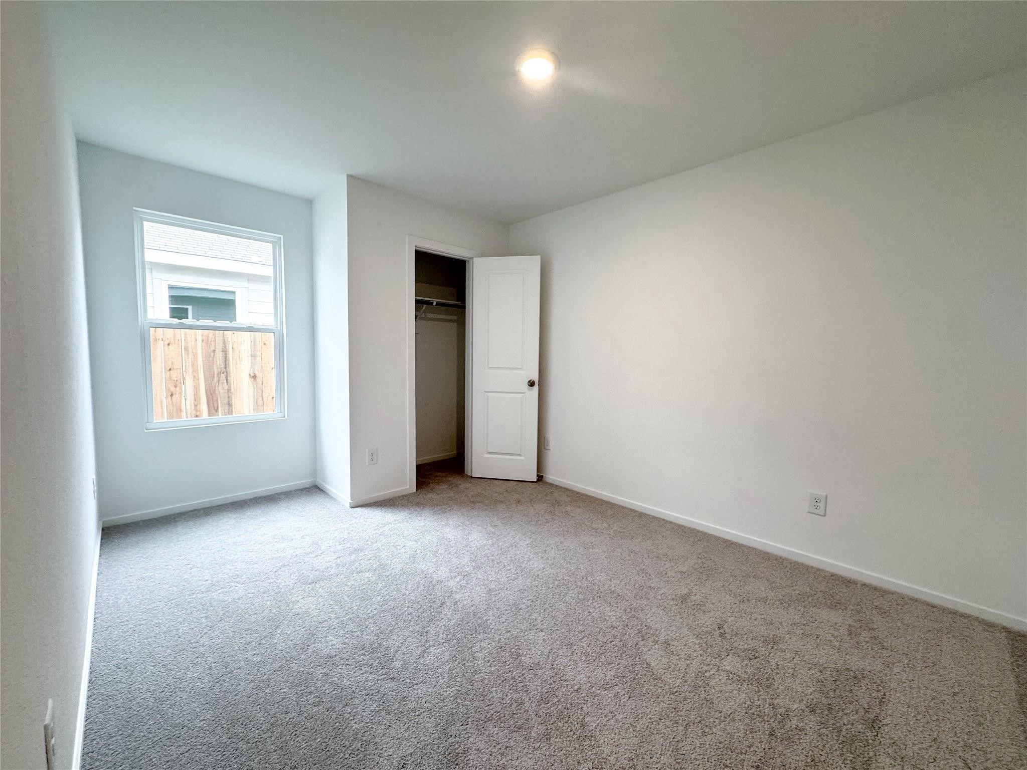 12431 Wild Strawberry Road Houston, TX 77038 - Photo 10 of 18 an empty room with windows and closet
