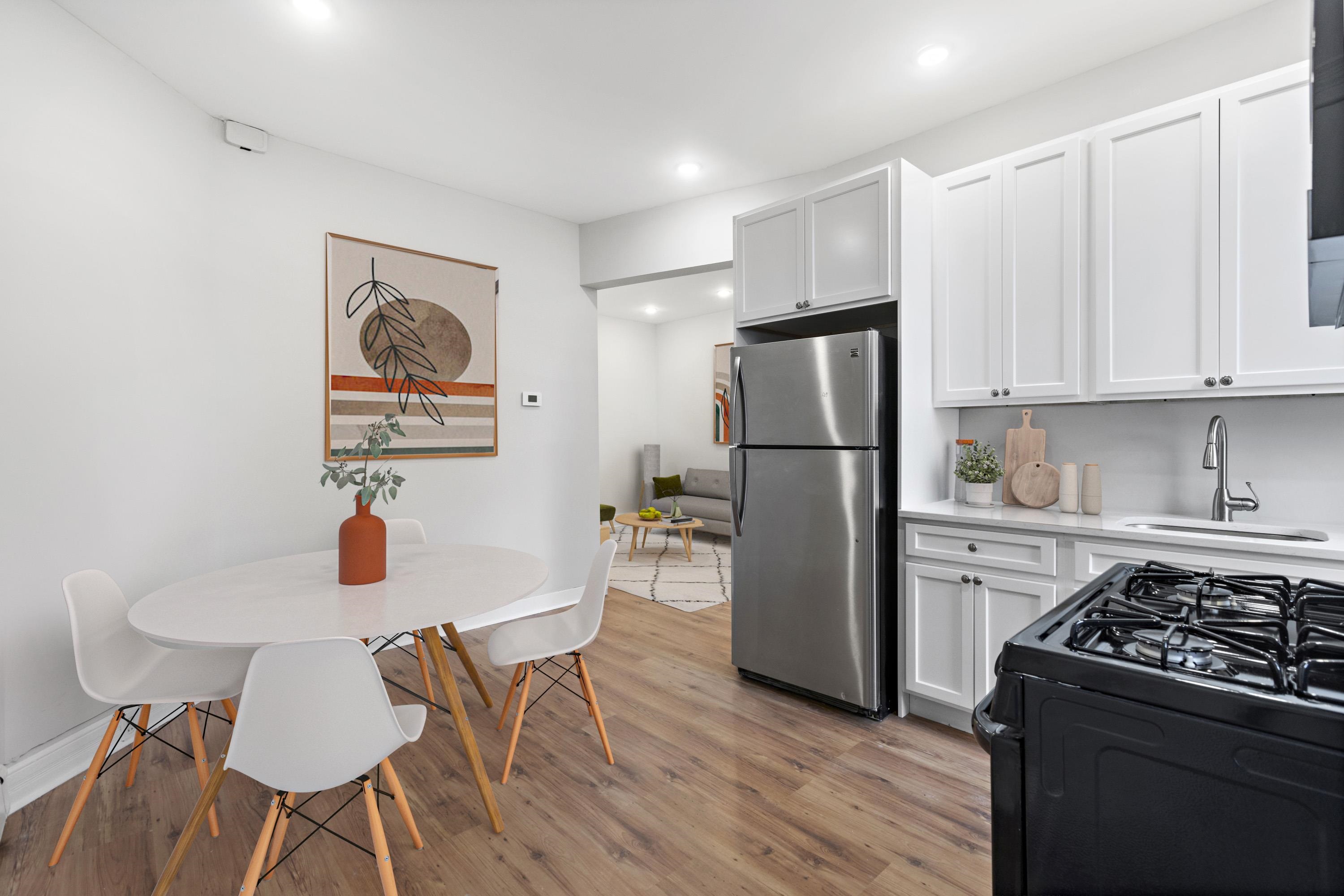 a kitchen with stainless steel appliances a stove a refrigerator a dining table and chairs