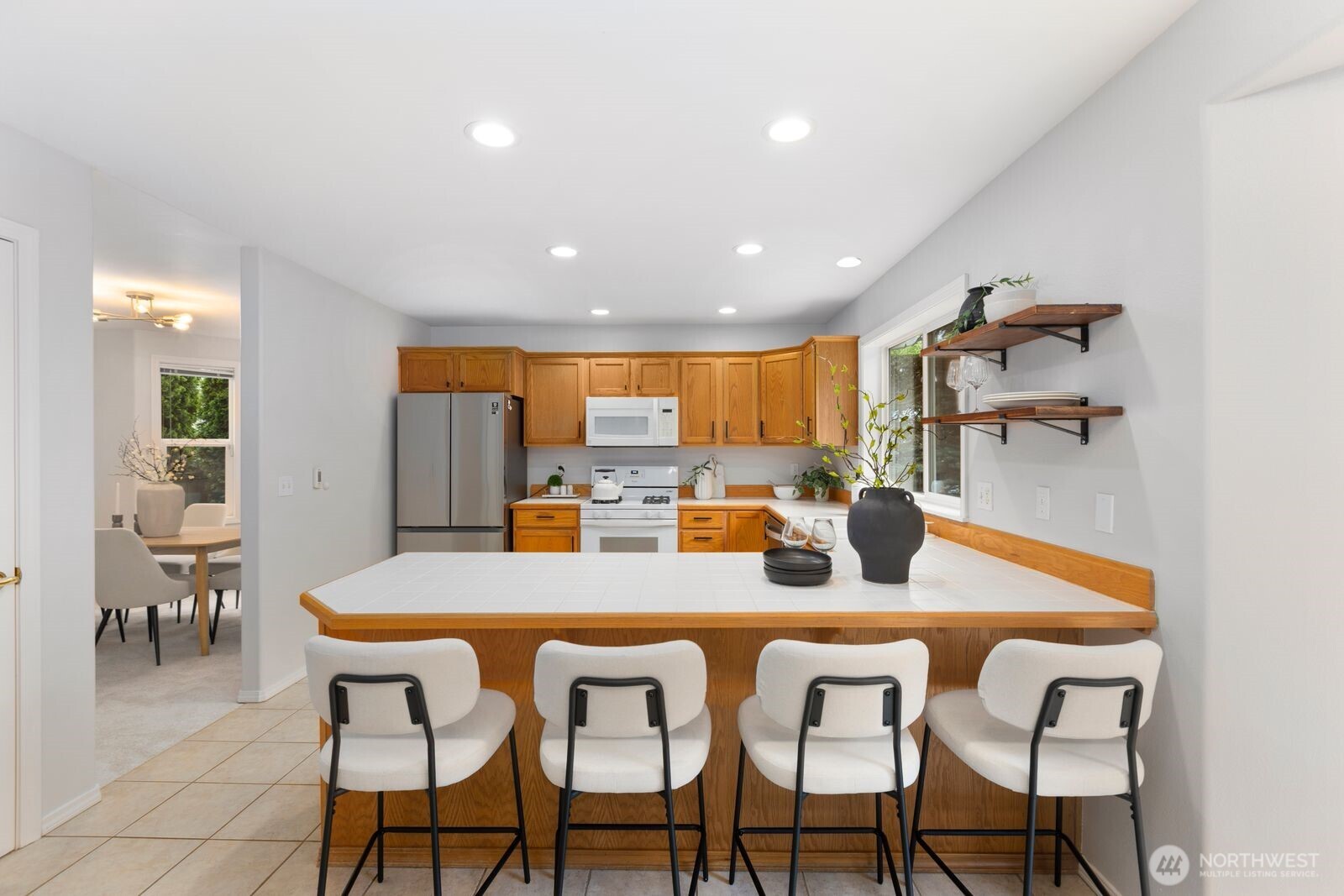 4405 South 261st Street Kent, WA 98032 - Photo 12 of 31 a kitchen with a dining table chairs and refrigerator