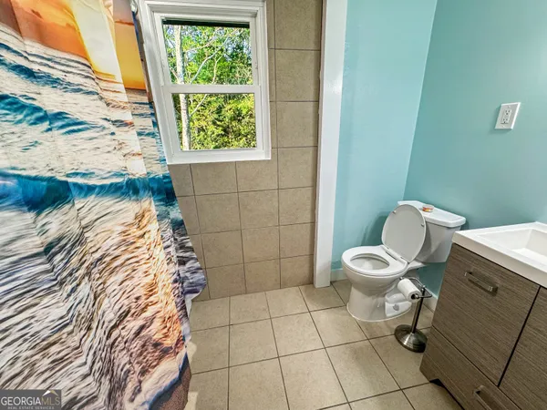 a bathroom with a toilet and a shower curtain
