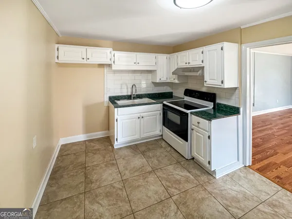 a kitchen with stainless steel appliances granite countertop a stove a refrigerator and a sink