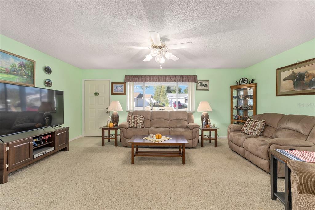 10913 Southwest 83rd Avenue Ocala, FL 34481 - Photo 12 of 48 a living room with furniture and a flat screen tv