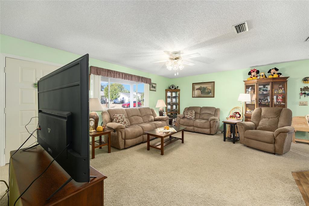 10913 Southwest 83rd Avenue Ocala, FL 34481 - Photo 13 of 48 a living room with furniture and a chandelier