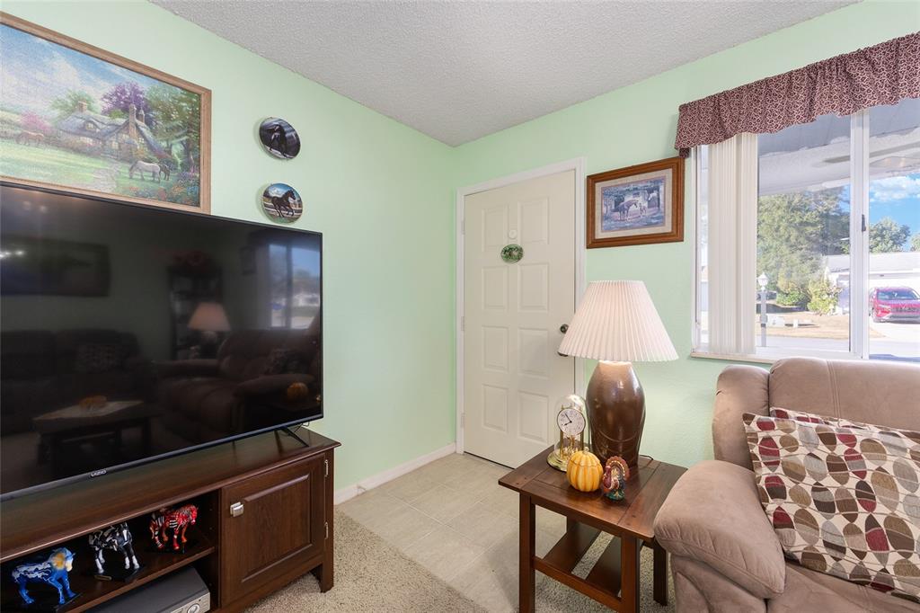 10913 Southwest 83rd Avenue Ocala, FL 34481 - Photo 14 of 48 a living room with furniture and a flat screen tv