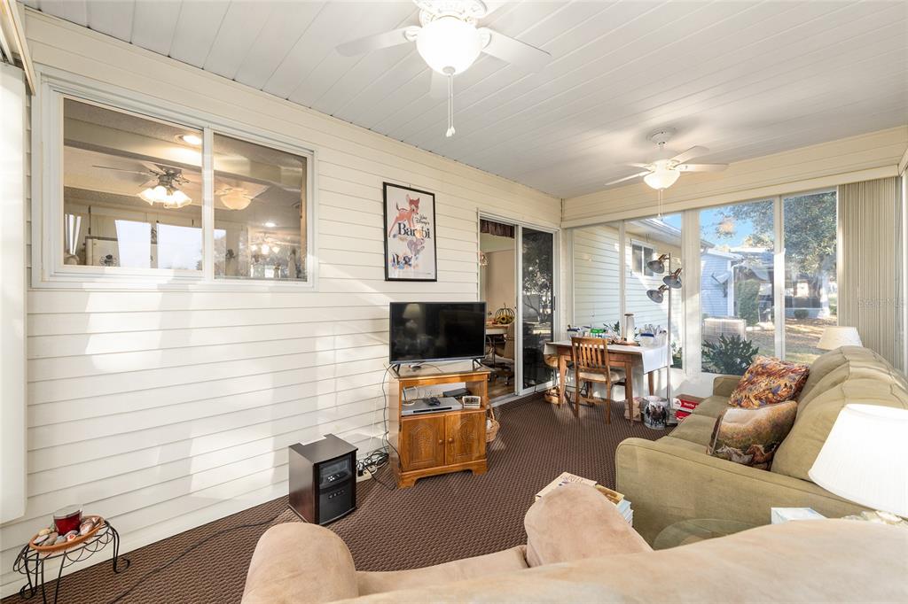 10913 Southwest 83rd Avenue Ocala, FL 34481 - Photo 36 of 48 a living room with furniture and a flat screen tv