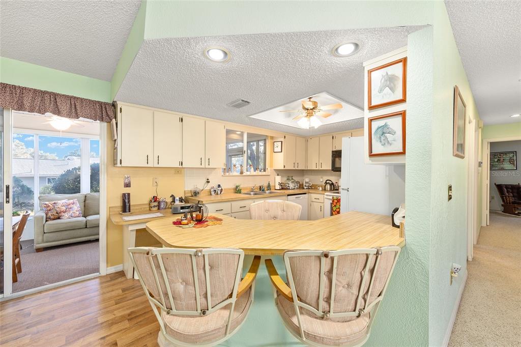 10913 Southwest 83rd Avenue Ocala, FL 34481 - Photo 5 of 48 a view of a kitchen with a dining table and chairs