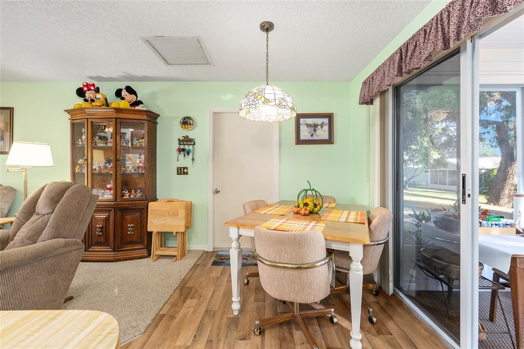 10913 Southwest 83rd Avenue Ocala, FL 34481 - Photo 8 of 48 a dining room with furniture a chandelier and wooden floor