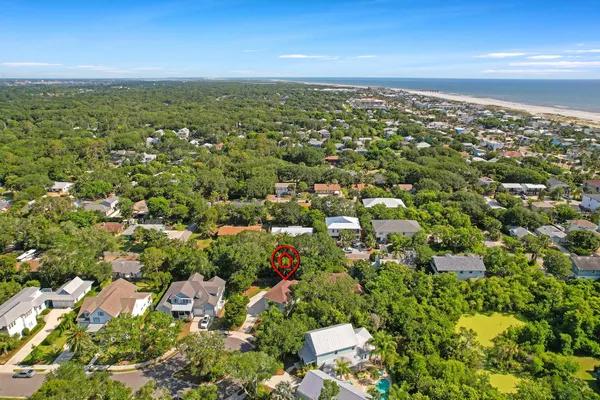 an aerial view of residential houses with outdoor space and trees