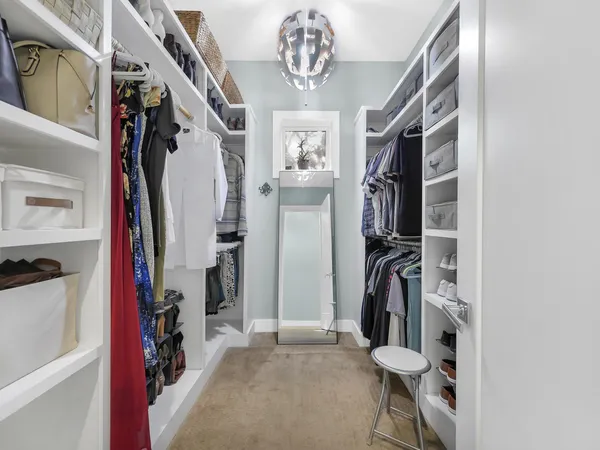a view of walk in closet with clothes and shoes
