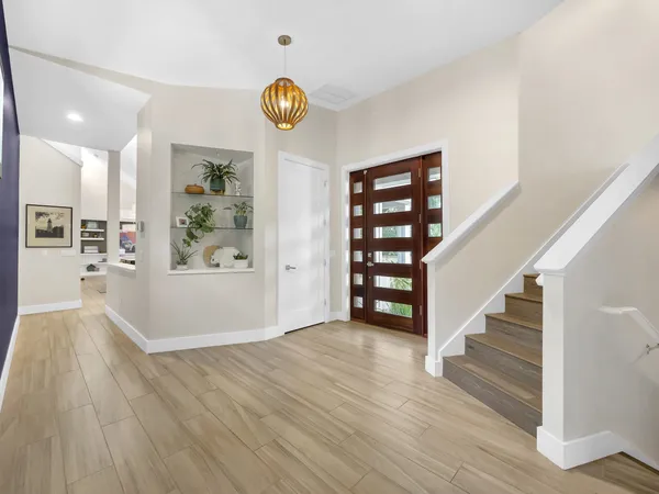a view of an empty room with wooden floor and windows