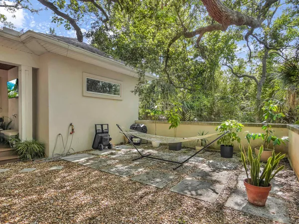 a view of a backyard with table and chairs and potted plants