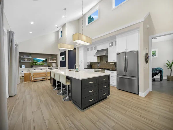 a kitchen with stainless steel appliances a sink a stove and cabinets