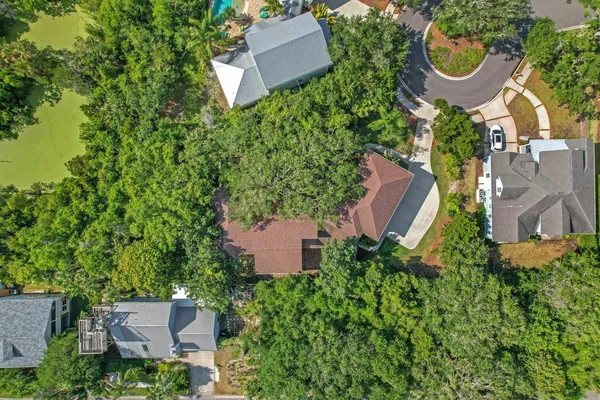 an aerial view of residential house with outdoor space and trees all around