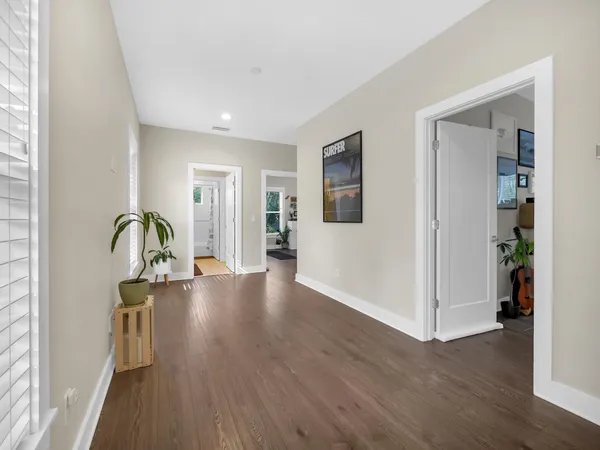 a view of empty room with wooden floor and window