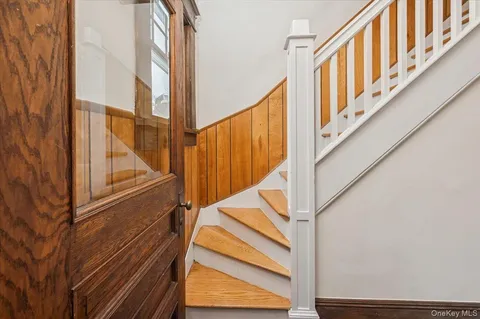a view of staircase with railing and a window