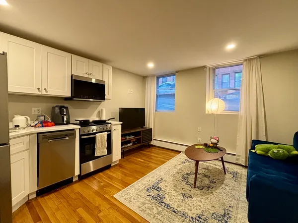 a kitchen with a sink cabinets and wooden floor
