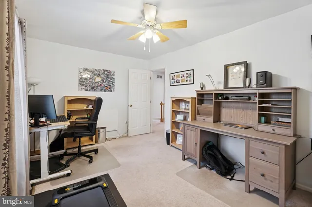 a bedroom with a bed and a flat tv screen on dresser