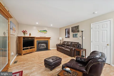 a living room with furniture a flat screen tv and a refrigerator