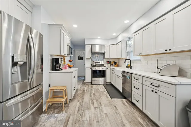 a kitchen with white cabinets sink and stove
