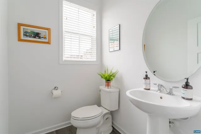 a bathroom with a toilet a sink and a mirror