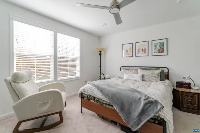 a bedroom with a bed a couch and a window