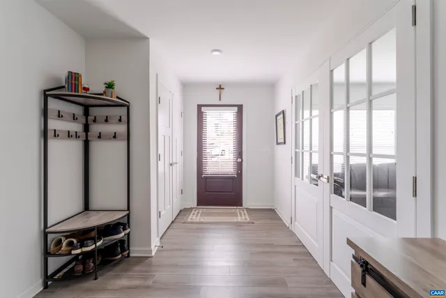 a view of a hallway with entryway wooden floor and front door