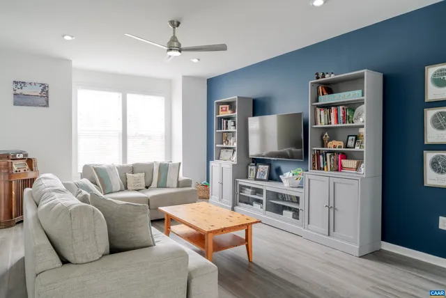 a living room with furniture a flat screen tv and a book shelf