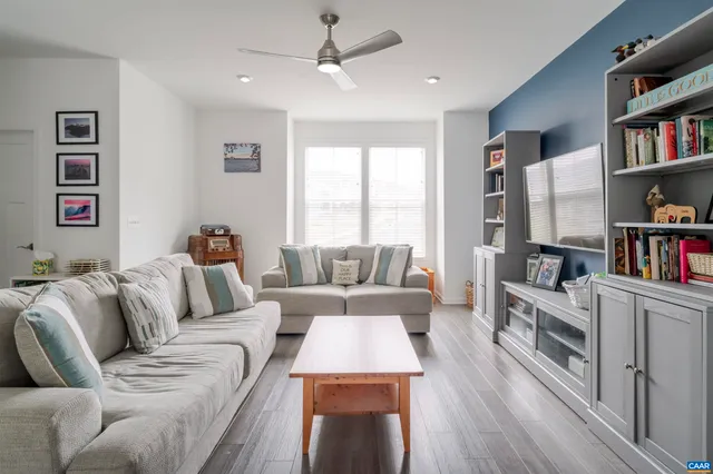 a living room with furniture and a book shelf