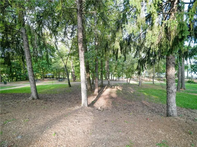 a view of an empty room with window and chandelier fan