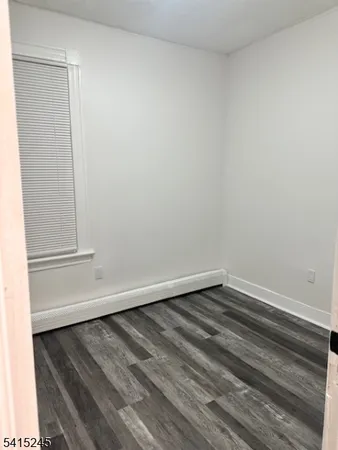 a view of a small space with wooden floor and a window