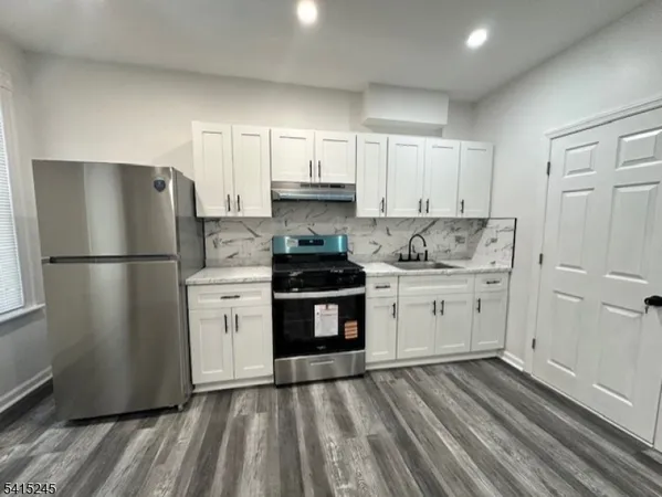 a kitchen with a sink a stove and refrigerator