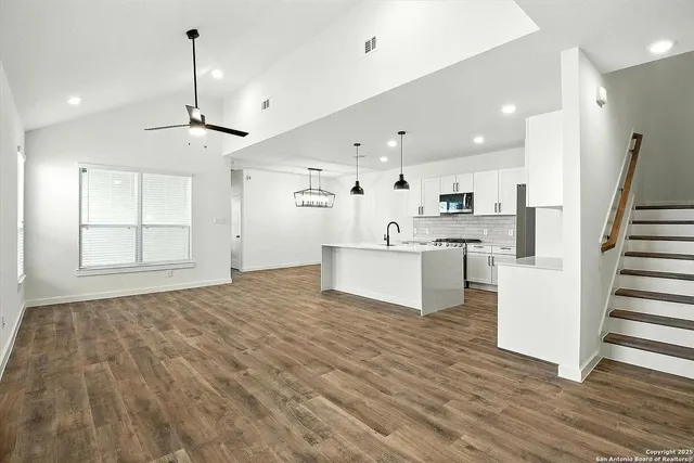 a view of a kitchen with wooden floor and electronic appliances