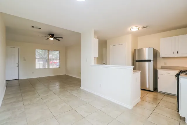 a view of a refrigerator in kitchen and a window
